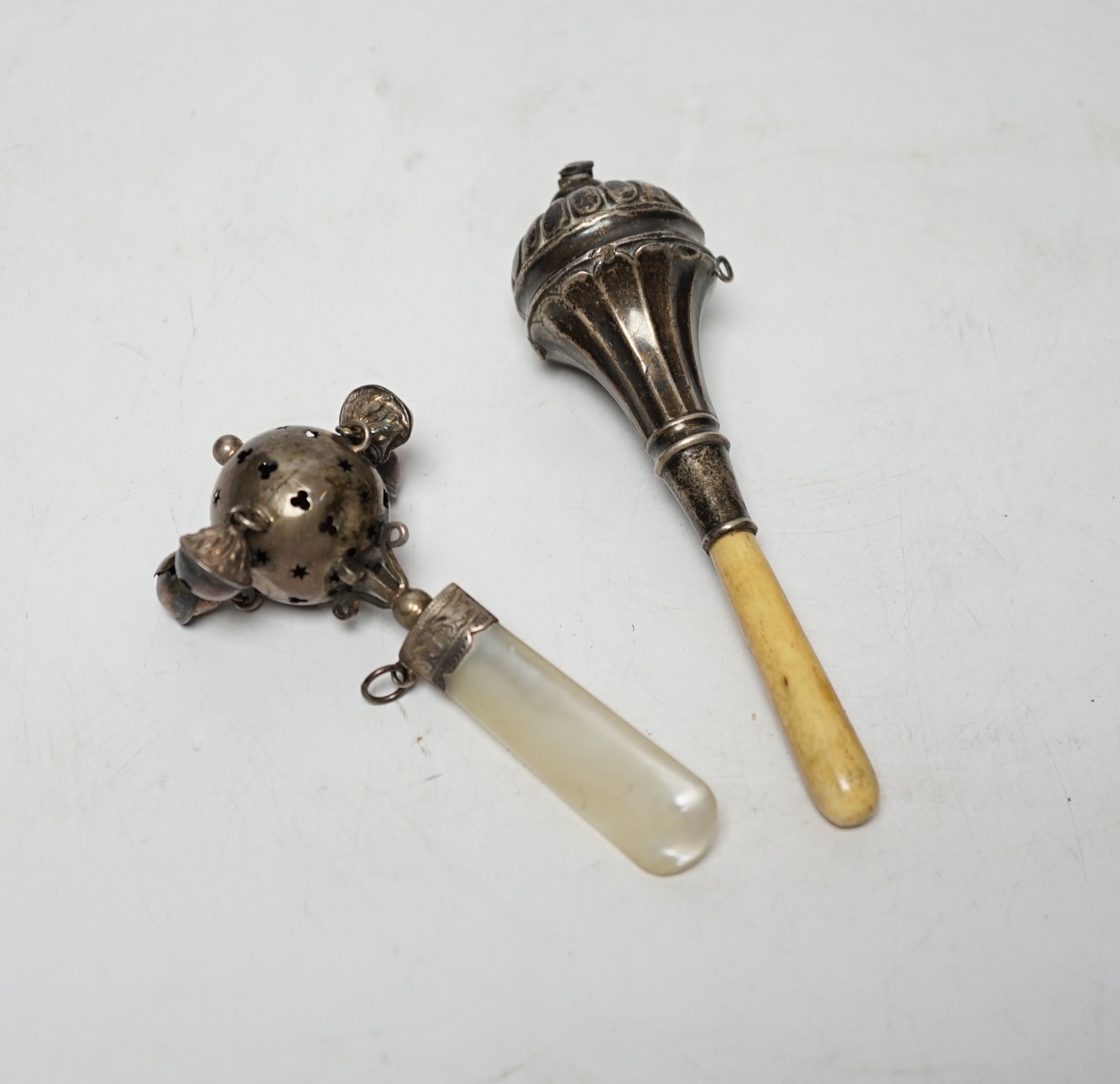 Two baby's silver rattles, Edwardian with mother of pearl handle, Birmingham, 1908, 10cm and later George V with bone handle and lacking bells.